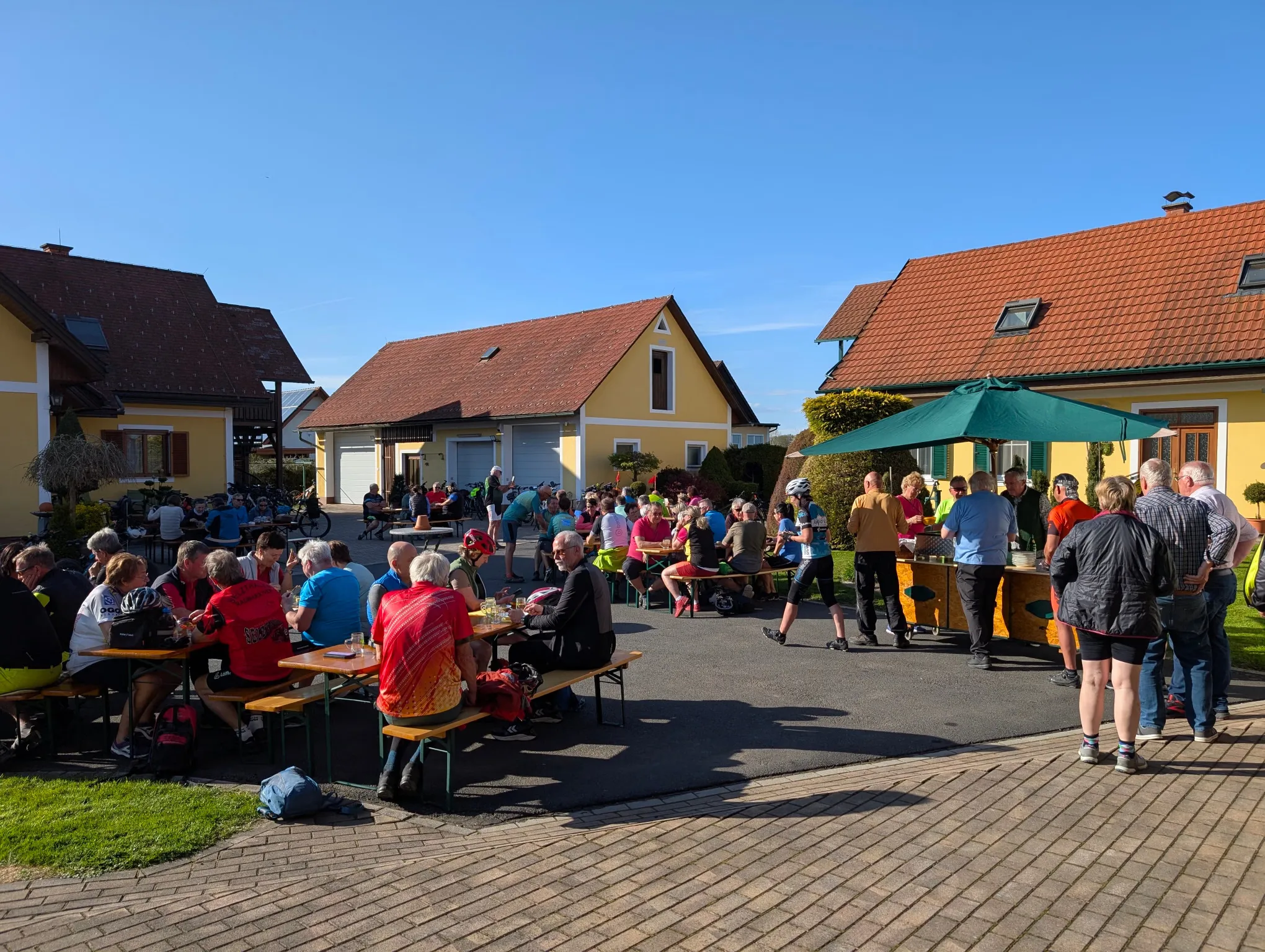 Radfahrer beim Anradeln an Tischen vor dem Hof Majczan