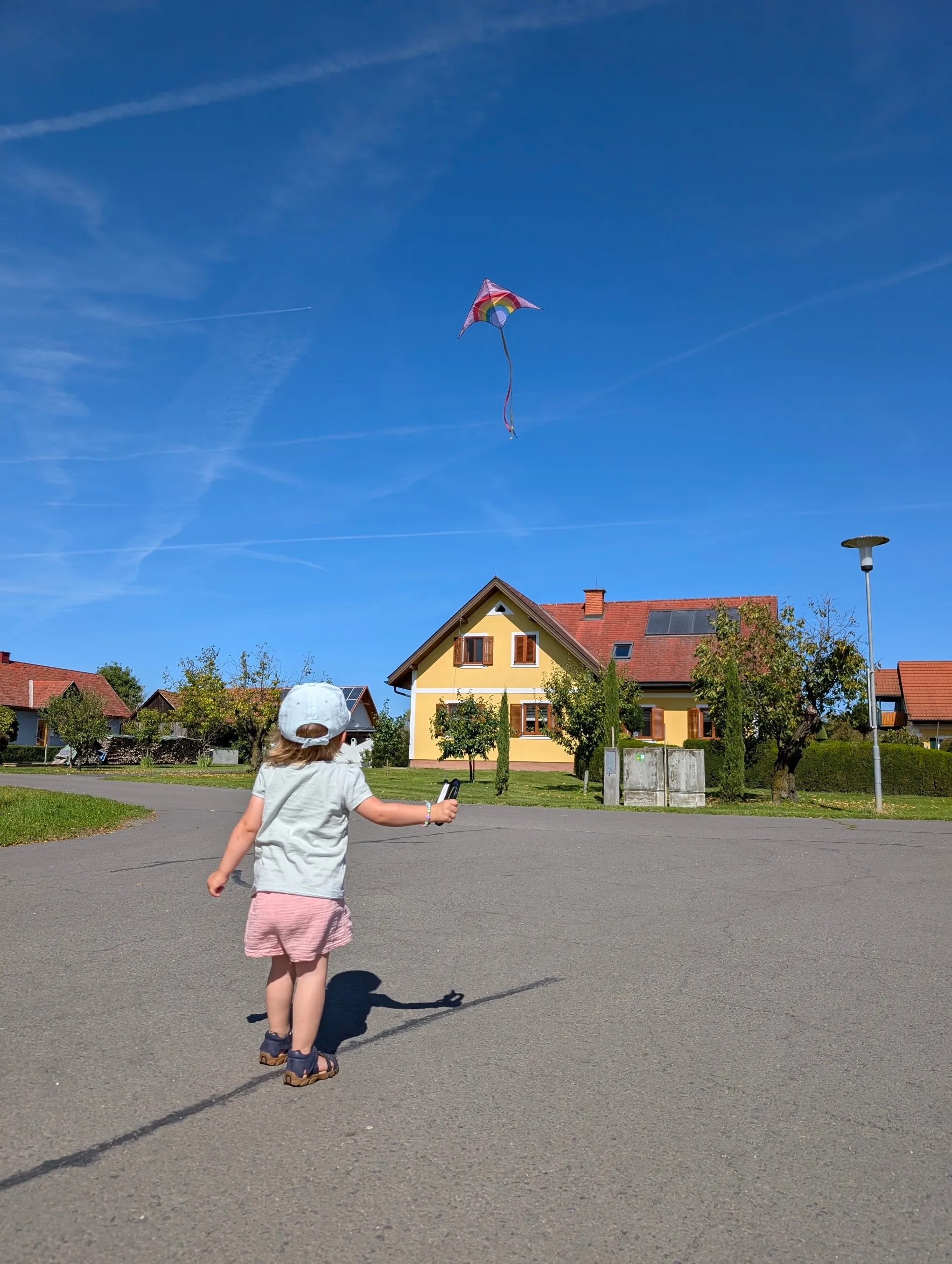 Kind lässt vor dem Hof Majczan einen Drachen steigen