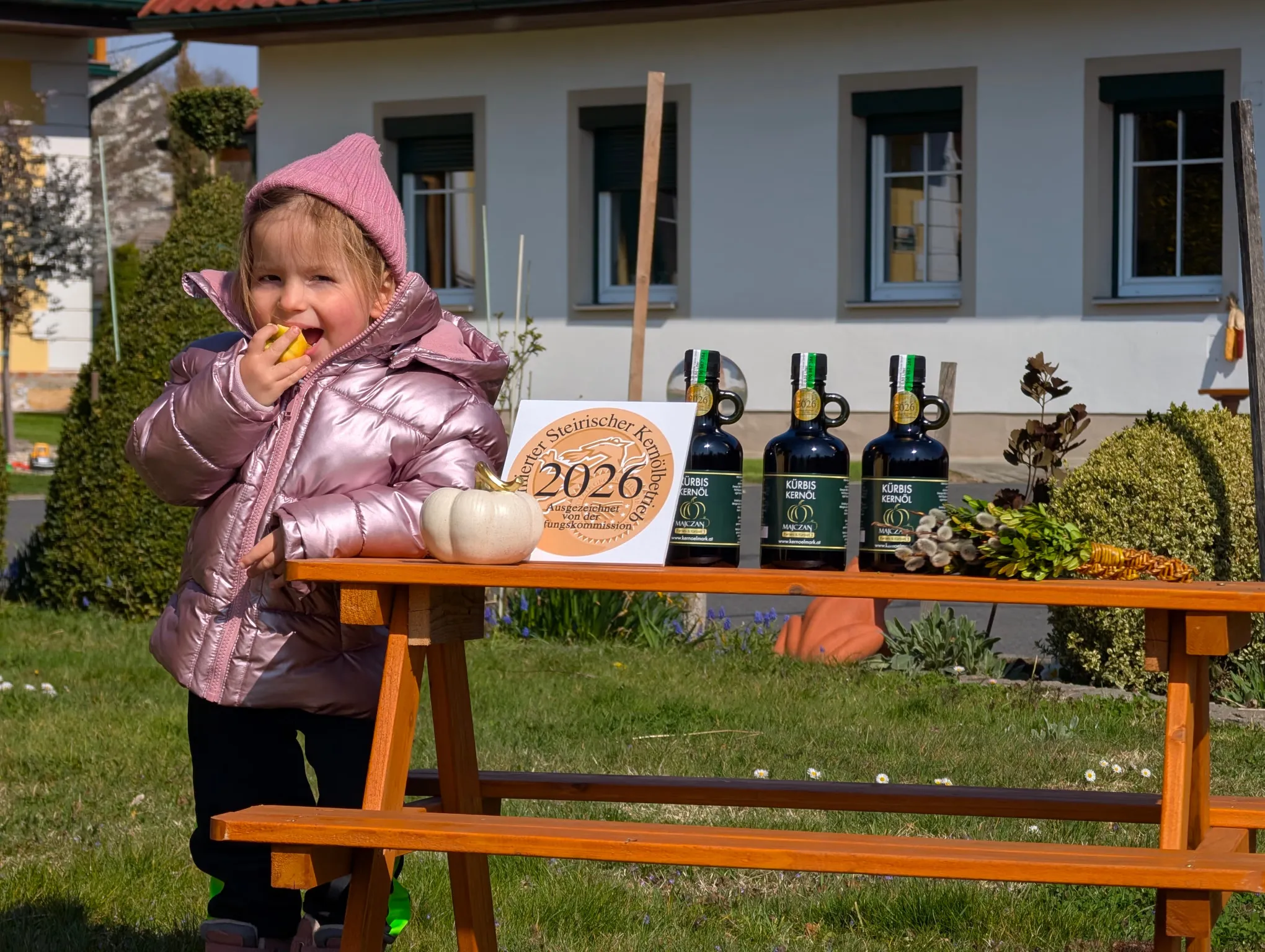 Kind mit prämiertem Kürbiskernöl vor dem Hof Majczan