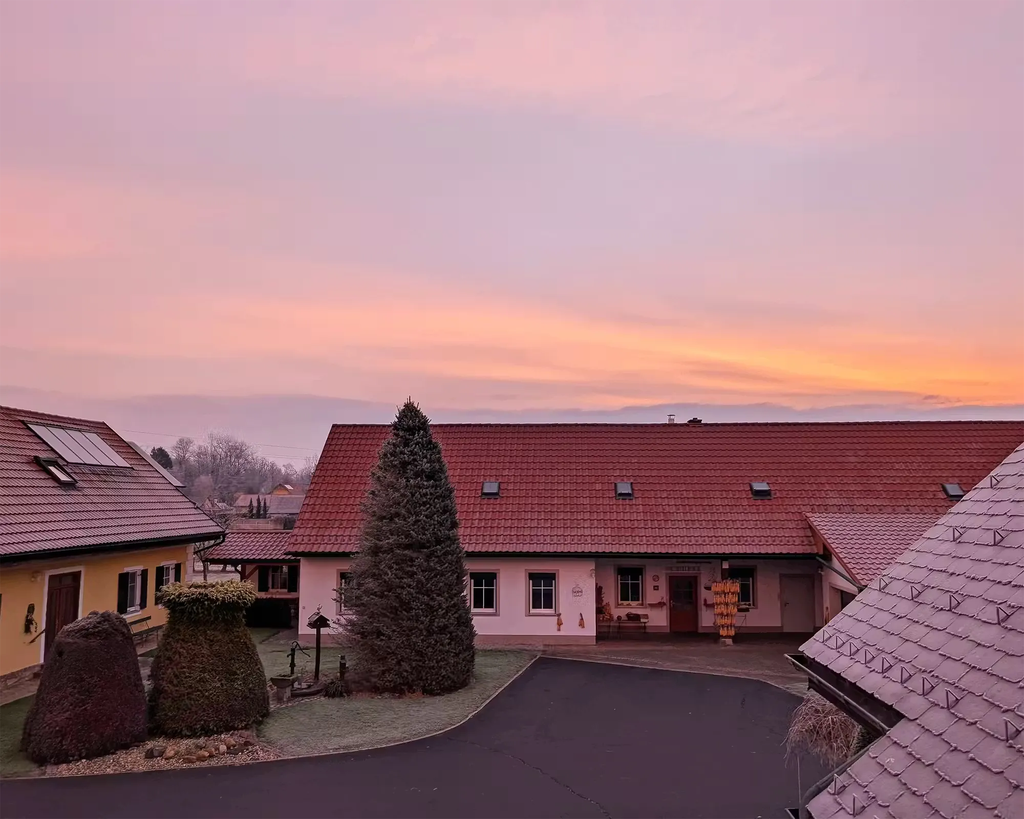 Winterlicher Hof Majczan unter einem rosa Morgenhimmel